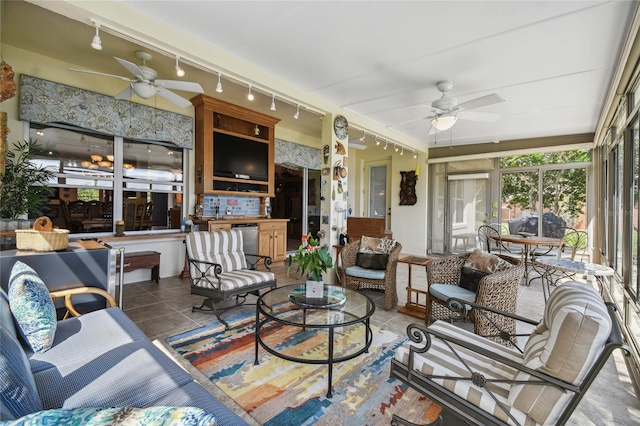 sunroom featuring ceiling fan and track lighting