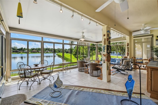 sunroom featuring ceiling fan, track lighting, and a water view