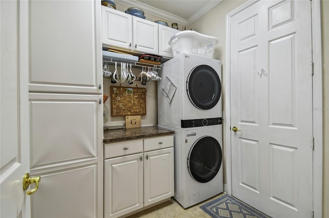 laundry room featuring ornamental molding, cabinets, and stacked washer / drying machine