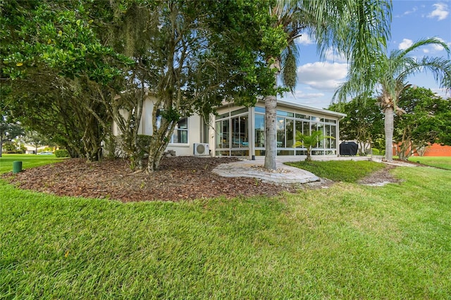 rear view of property with a sunroom and a yard