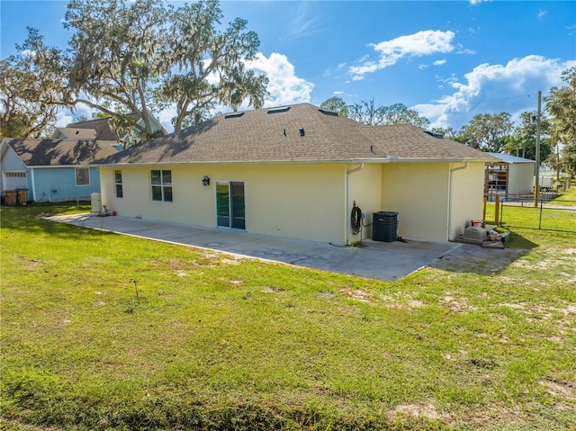 back of house featuring cooling unit, fence, a yard, stucco siding, and a patio area