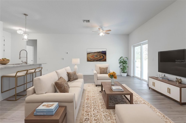 living room with light hardwood / wood-style floors and ceiling fan