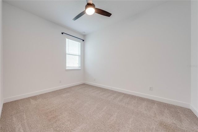 spare room with baseboards, light colored carpet, and a ceiling fan