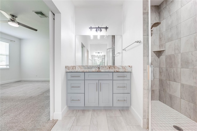 full bathroom with visible vents, tiled shower, vanity, and a ceiling fan