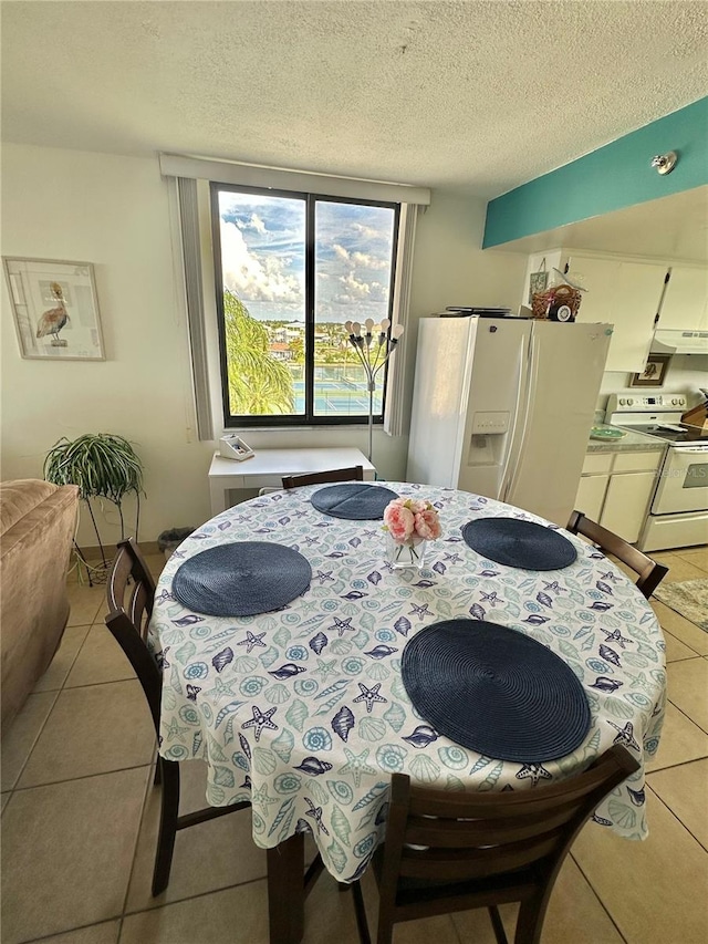 tiled dining space featuring a textured ceiling