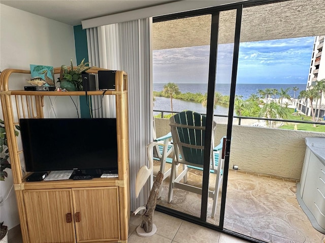 doorway to outside featuring a healthy amount of sunlight, a water view, and light tile patterned flooring