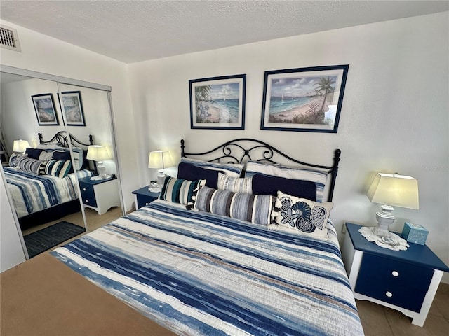 bedroom with a textured ceiling and a closet