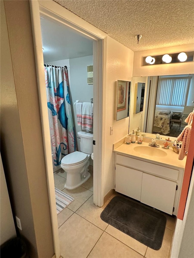 bathroom featuring vanity, toilet, a textured ceiling, and tile patterned floors