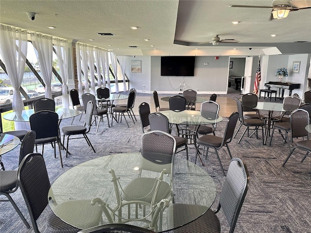 dining area featuring ceiling fan and a textured ceiling