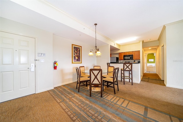 dining area with dark carpet, an inviting chandelier, and crown molding