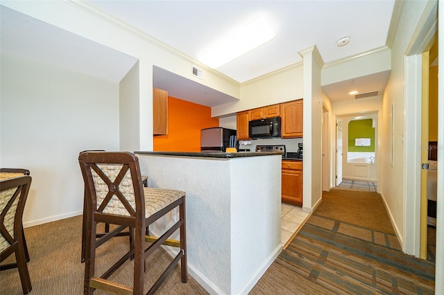 kitchen featuring light carpet, kitchen peninsula, crown molding, and stainless steel refrigerator