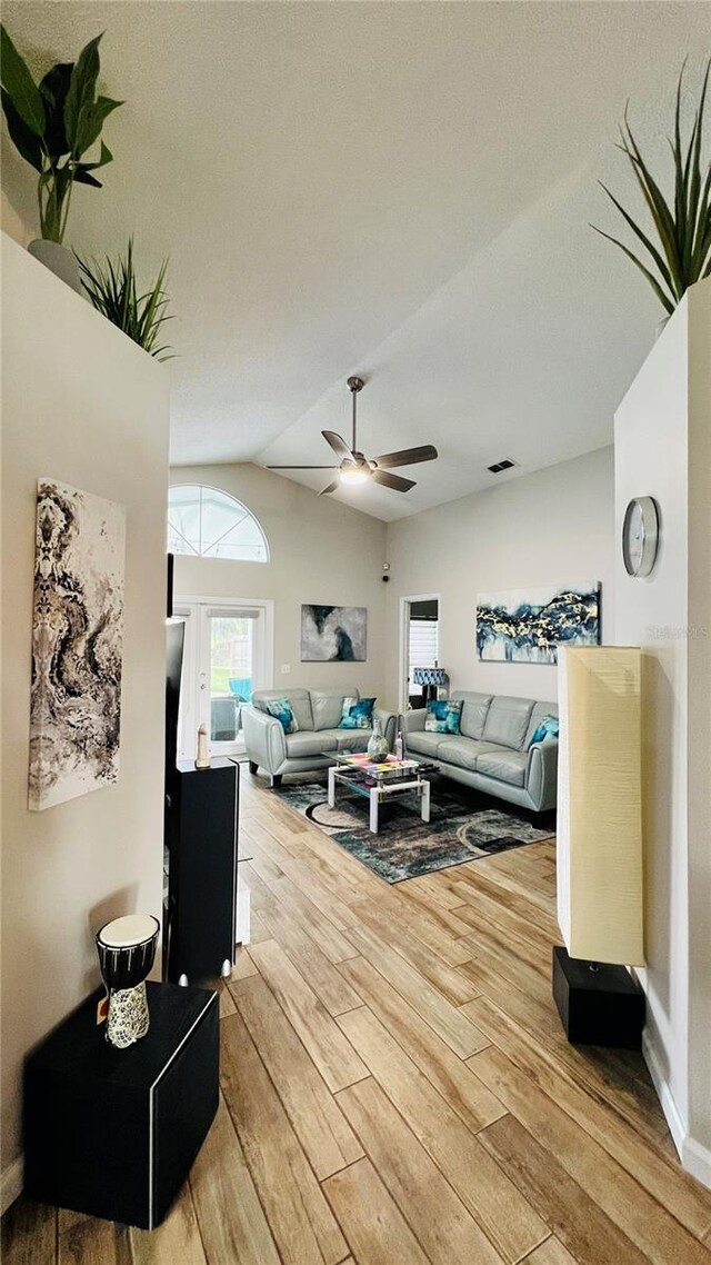 living room featuring ceiling fan, hardwood / wood-style flooring, and lofted ceiling