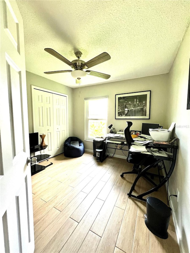 office featuring ceiling fan, a textured ceiling, and light hardwood / wood-style flooring