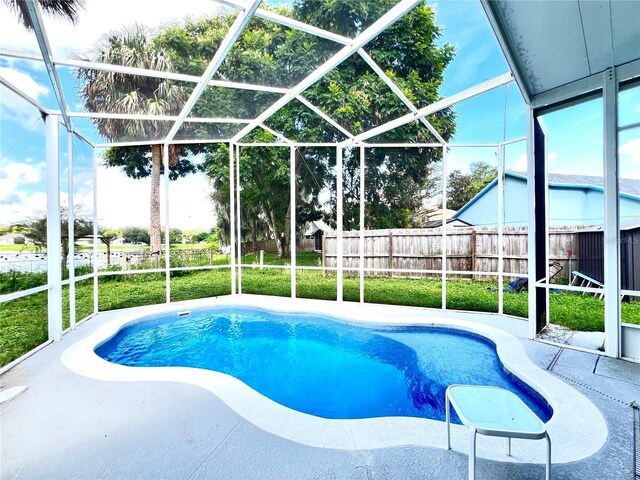view of swimming pool featuring a fenced in pool, a patio area, a lanai, fence, and a lawn
