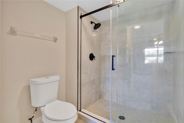 bathroom featuring toilet and a shower with shower door