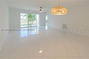 tiled spare room featuring ceiling fan