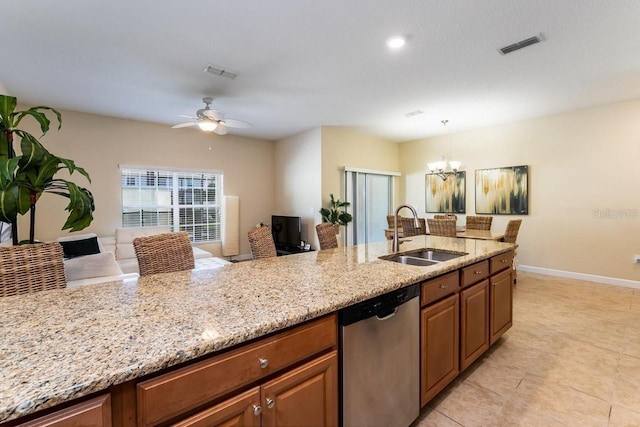 kitchen with light stone counters, ceiling fan with notable chandelier, dishwasher, pendant lighting, and sink