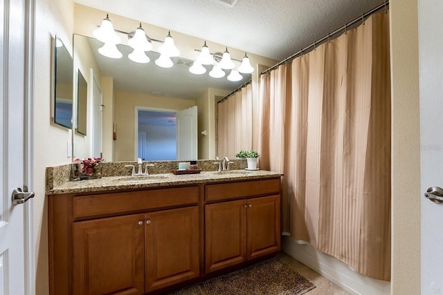 bathroom with a textured ceiling, tile patterned flooring, vanity, and shower / bath combo with shower curtain