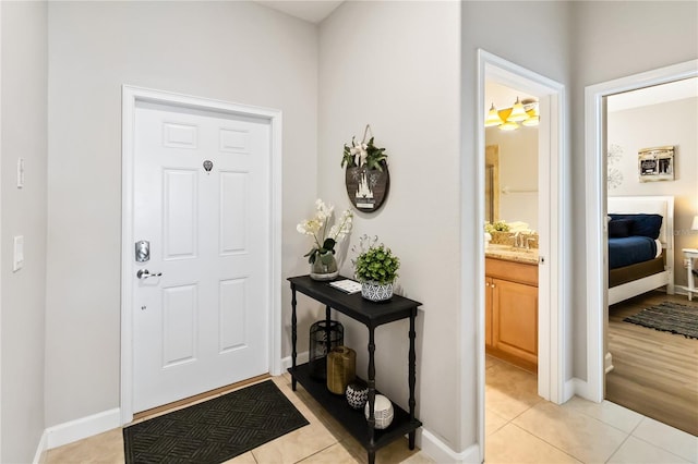 foyer featuring light tile patterned flooring and baseboards