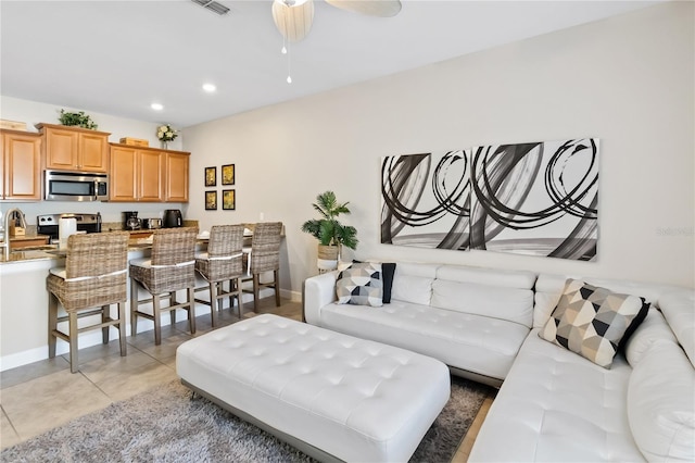 living room with light tile patterned floors, visible vents, baseboards, and recessed lighting