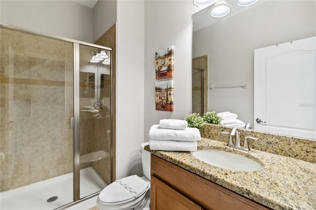 full bathroom featuring toilet, a stall shower, and vanity