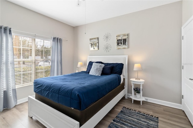 bedroom with baseboards and wood finished floors