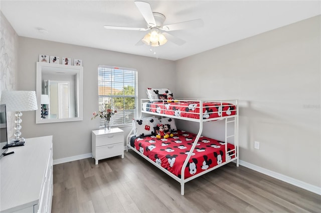 bedroom featuring wood finished floors, a ceiling fan, and baseboards