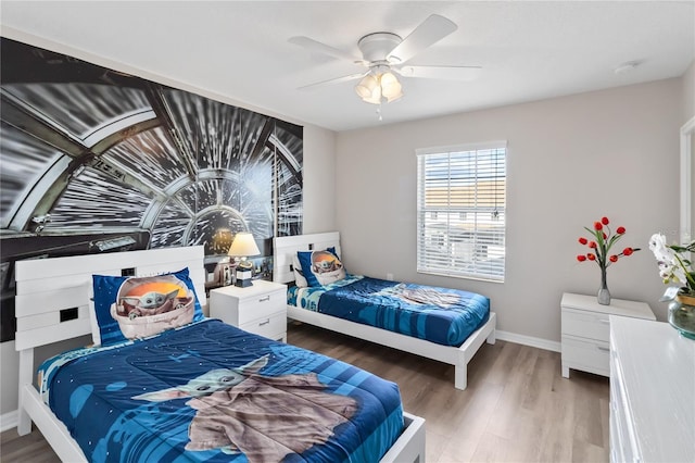 bedroom featuring a ceiling fan, baseboards, and wood finished floors