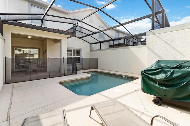 pool featuring glass enclosure and a patio