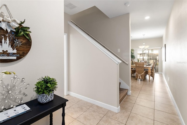 interior space with baseboards, tile patterned flooring, visible vents, and an inviting chandelier