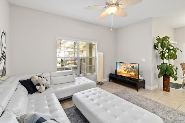 tiled living area with ceiling fan and baseboards