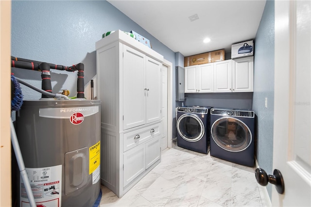 laundry area featuring water heater, washing machine and dryer, and cabinets