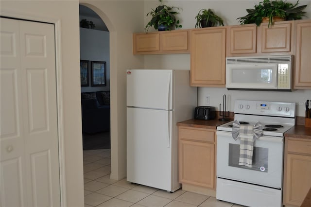 kitchen with white appliances, light brown cabinets, and light tile patterned floors