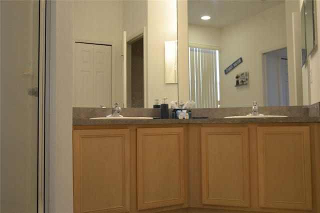 bathroom with a shower with shower door and vanity