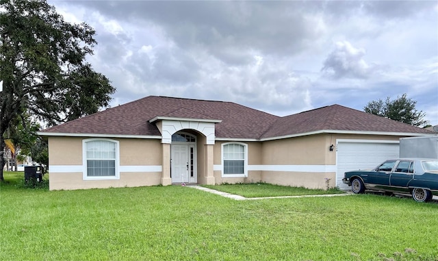 ranch-style house featuring a garage and a front lawn