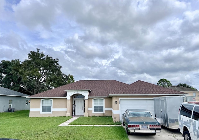 single story home featuring a front lawn, central air condition unit, and a garage