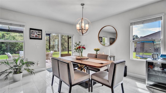 dining room featuring an inviting chandelier, beverage cooler, and a healthy amount of sunlight