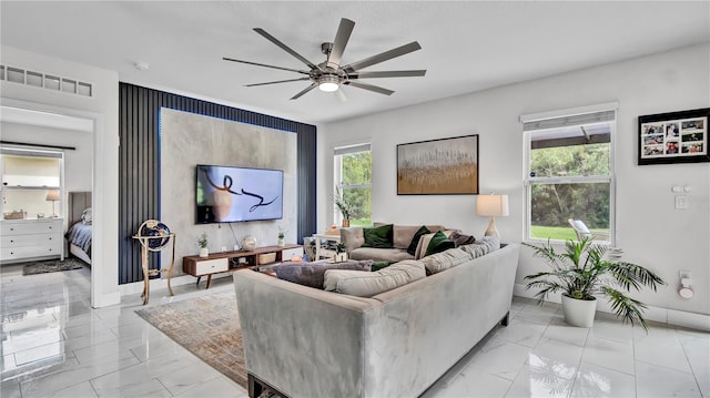 living room with a wealth of natural light and ceiling fan