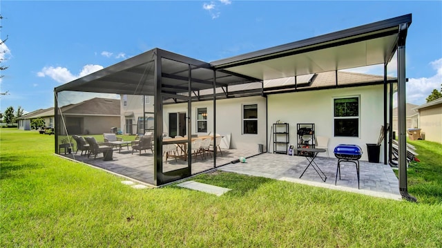 back of house featuring a lawn, a patio, and glass enclosure