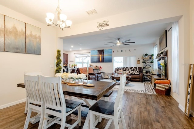 dining room with wood-type flooring and ceiling fan with notable chandelier