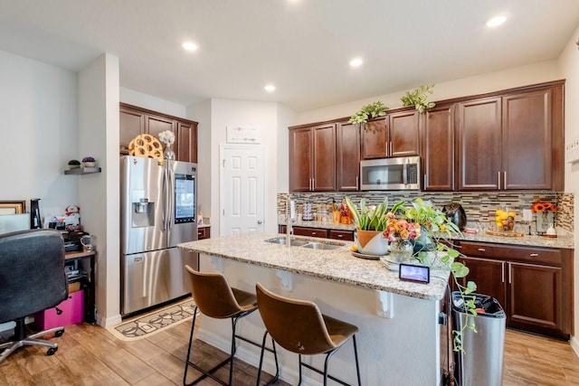 kitchen featuring light hardwood / wood-style flooring, an island with sink, and stainless steel appliances