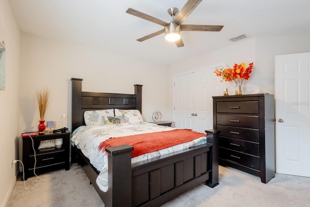 carpeted bedroom with ceiling fan and a closet