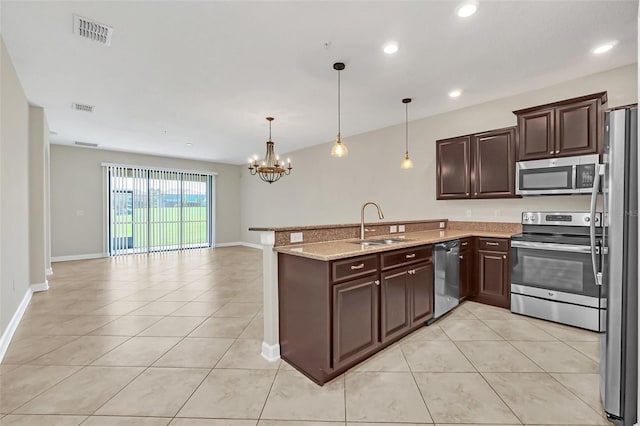 kitchen with appliances with stainless steel finishes, hanging light fixtures, an inviting chandelier, and sink