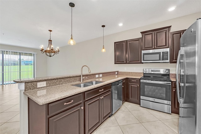 kitchen with pendant lighting, appliances with stainless steel finishes, sink, and kitchen peninsula