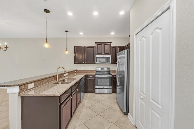 kitchen featuring sink, kitchen peninsula, appliances with stainless steel finishes, dark brown cabinetry, and decorative light fixtures