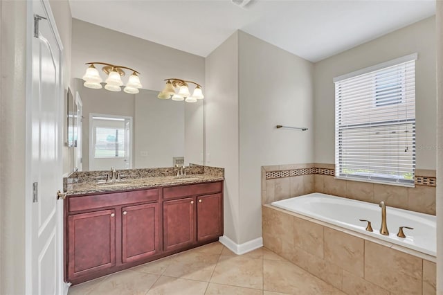 bathroom with tiled bath, vanity, and plenty of natural light