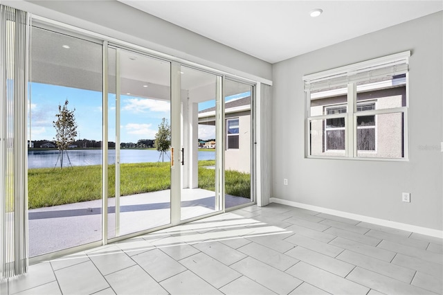 entryway with light tile patterned floors and a water view