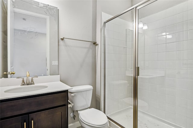 bathroom featuring vanity, toilet, and an enclosed shower