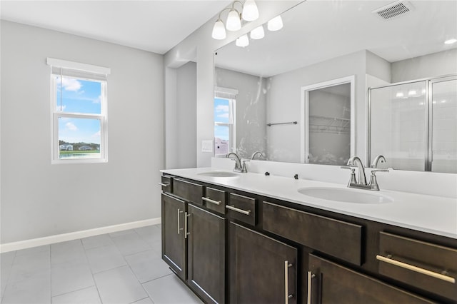 bathroom featuring vanity, a shower with shower door, and tile patterned flooring