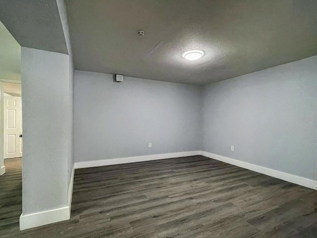 basement with a textured ceiling and dark wood-type flooring